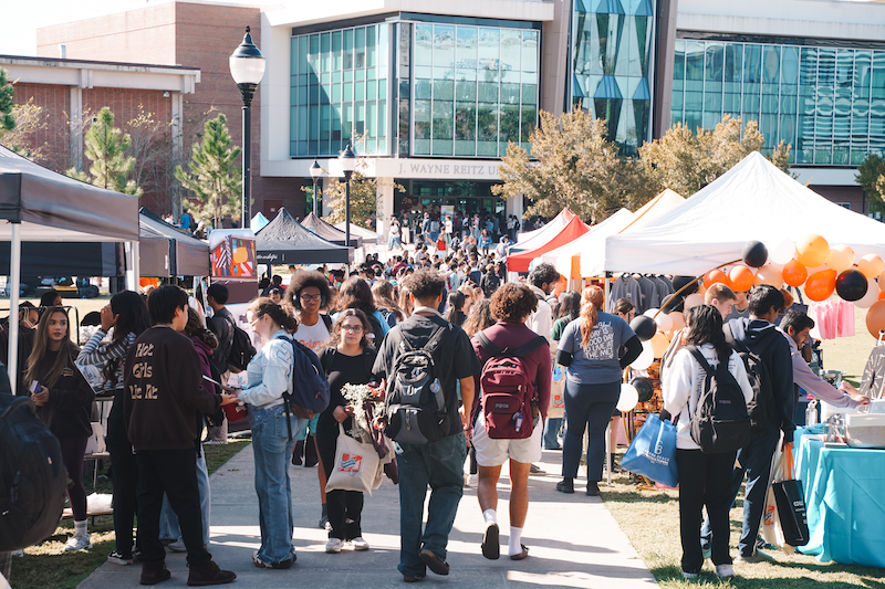 Tents set up outside and students walking around, talking to off-campus housing personnel